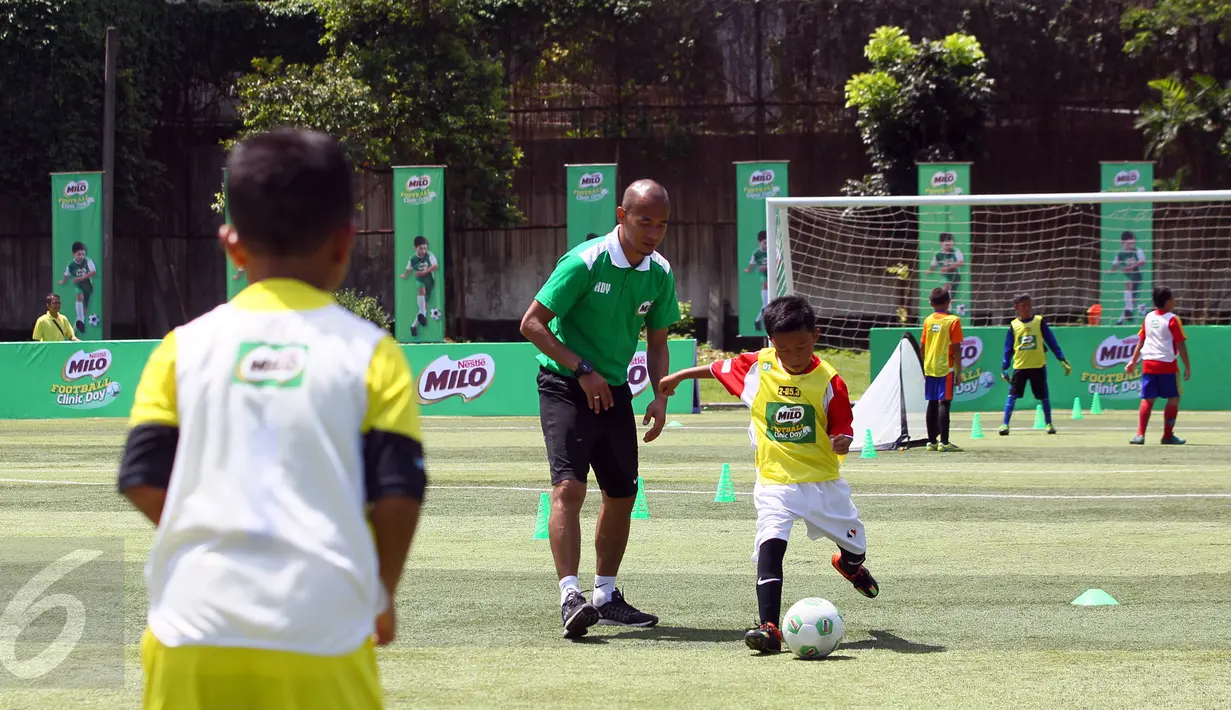 Kurniawan Dwi Yulianto sedang memberikan arahan kepada salah satu peserta MILO Football Clinic Day mengenai teknik menendang bola di Lapangan Sepakbola Pertamina-Simprug, Jakarta (29/10). (Liputan6.com/Istimewa)