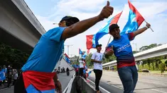 Pendukung Pakatan Harapan memadati jalan menuju Istana Negara menjelang pelantikan Mahathir Mohamad sebagai Perdana Menteri Malaysia di Kuala Lumpur, Kamis (10/5). Mahathir akan menjadi perdana menteri ketujuh Negeri Jiran. (AFP/Manan VATSYAYANA)