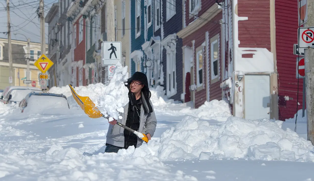 Warga menggali salju untuk membuat jalan dari rumahnya di Kota St John's, Newfoundland, Kanada, Sabtu (18/1/2020). St John's menghadapi keadaan darurat ketika salju tebal memaksa pusat-pusat bisnis tutup dan kendaraan dilarang melintas di jalan raya. (Andrew Vaughan/The Canadian Press via AP)