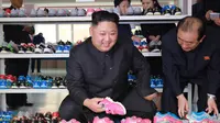 Pemimpin Korea Utara Kim Jong-Un mengecek sepatu saat mengunjungi pabrik sepatu Ryuwon di Pyongyang 19 Oktober 2017. (AFP Photo/KCNA Via KNS/Str/South Korea Out/Republic Of Korea Out)