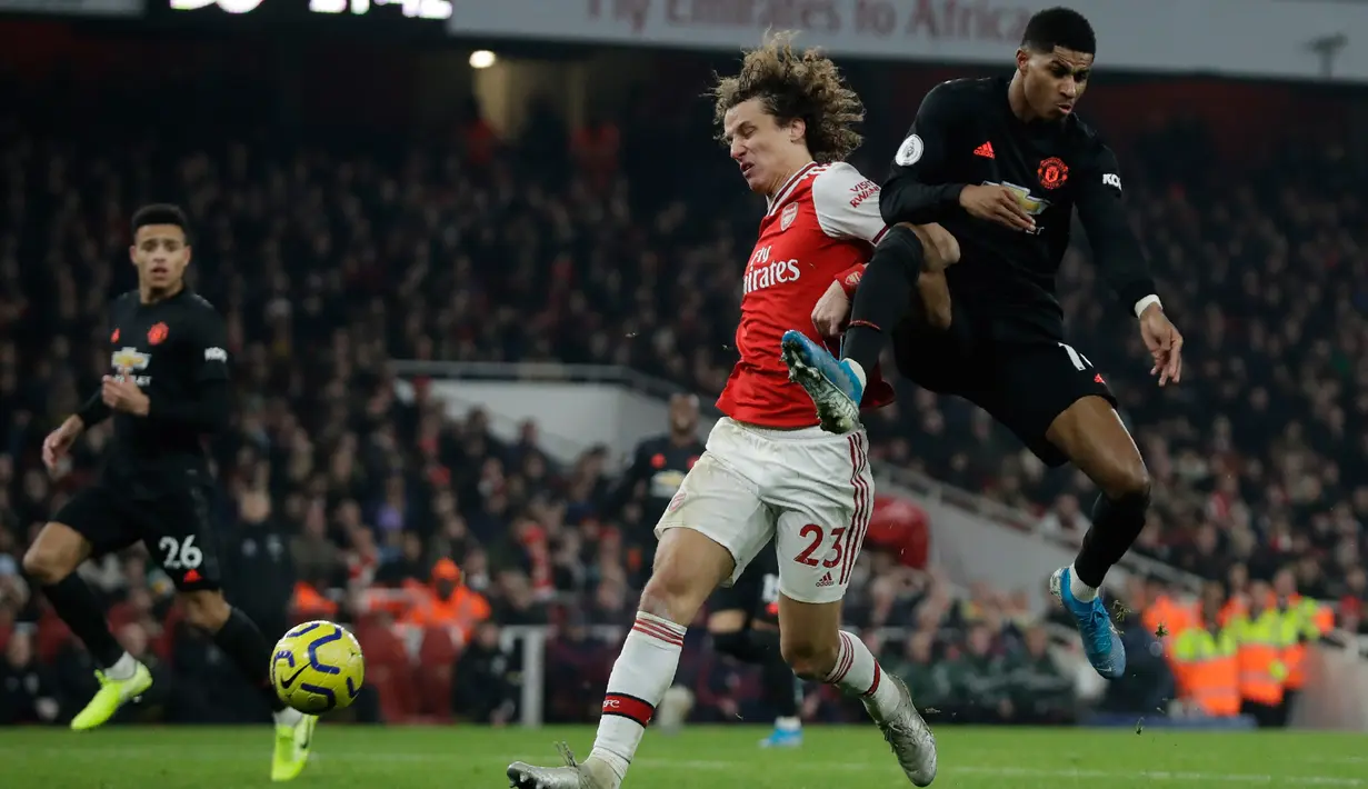 Pemain Arsenal David Luiz (kiri) berebut bola dengan pemain Manchester United Marcus Rashford pada pertandingan lanjutan Liga Inggris di Emirates Stadium, London, Rabu (1/1/2020). Arsenal menang 2-0. (AP Photo/Matt Dunham)