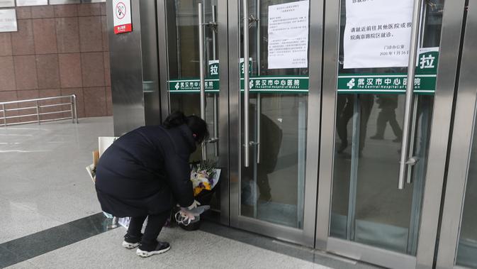 Warga menaruh bunga untuk mendiang dokter mata Li Wenliang di Cabang Houhu Rumah Sakit Pusat Wuhan di Wuhan di provinsi Hubei, China, Jumat, (7/2/2020). Li Wenliang meninggal karena virus corona di Wuhan pada pukul 02.58 Jumat dini hari waktu setempat. (AFP/STR)