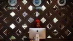 Seorang resepsionis mengamati layar komputer di balik meja di hotel Al Meroz, Bangkok, (29/8). Thailand yang mayoritas penduduknya Buddhis telah membuka hotel halal pertama dengan harapan akan menarik lebih banyak turis Muslim. (REUTERS/Chaiwat Subprasom)