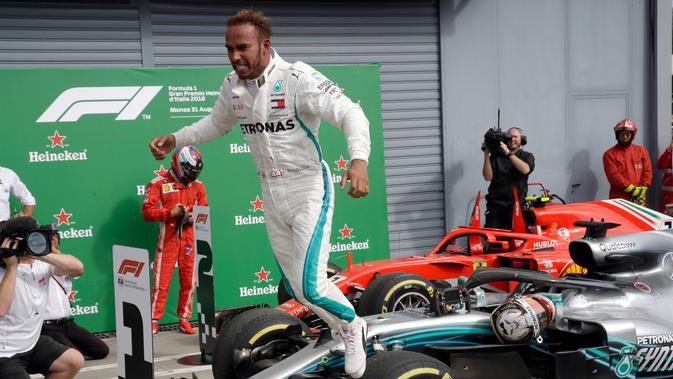 Pembalap Mercedes, Lewis Hamilton melompat dari mobilnya usai meraih kemenangan GP Italia di Sirkuit Monza di Monza, (2/9). Hamilton sudah meraih enam podium tertinggi di F1 2018. (AP Photo/Luca Bruno)