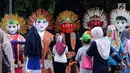 Warga berkerumun di depan deretan ondel-ondel di kawasan silang Monumen Nasional, Jakarta, Minggu (26/11). Deretan ondel-ondel ini bagian kemeriahan Kirab Kebangsaan yang diadakan Bamus Betawi. (Liputan6.com/Helmi Fithriansyah)