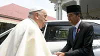 Paus Fransiskus bersalaman dengan Presiden Republik Indonesia, Joko Widodo (Jokowi), saat kunjungannya ke Jakarta, Indonesia, di Istana Presiden, Rabu (4/9/2024) siang WIB. (Handout / VATICAN MEDIA / AFP)