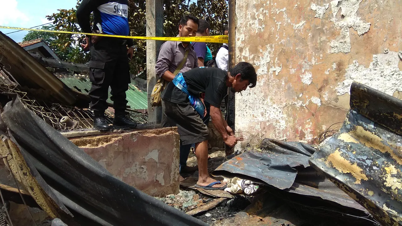 Seorang warga mengumpulkan sisa kebakaran di Kampung Gudang, Bogor Tengah. (Liputan6.com/Achmad Sudarno)