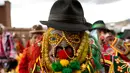 Seorang pria mengenakan kostum lengkap dengan topengnya bersiap mengikuti karnaval Anata Andina (Andean karnaval) di Caquiaviri, Bolivia, Selasa (17/1). Acara tersebut juga dimeriahkan dengan tarian tradisional dan adu banteng. (AP Photo/Juan Karita)