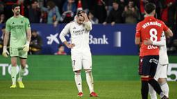 Raut kecewa pemain Real Madrid, Raul Asencio setelah Osasuna mencetak gol kedua mereka dalam laga lanjutan Liga Spanyol di El Sadar Stadium, Pamplona, Spanyol, Sabtu (21/02/2026) waktu setempat. (AFP/Ander Gillenea)