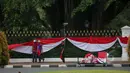Sejumlah pekerja sibuk memasang kain berwarna merah putih dipagar depan Istana Merdeka Jakarta, Senin (13/4/2015). Jelang Konferensi Asia Afrika (KAA) ke-60 di Bandung pada 24 April mendatang, Istana Merdeka mulai dipercantik. (Liputan6.com/Faizal Fanani)