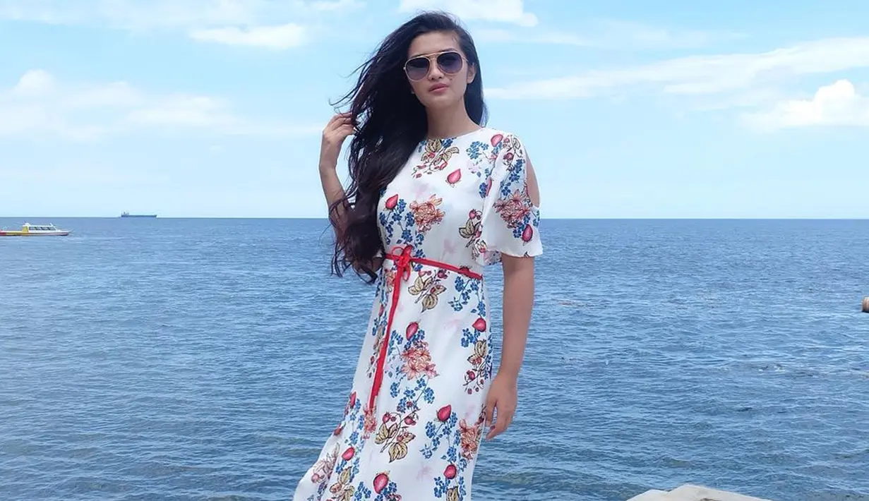 Gaya pelantun lagu ABG TUA saat menggunakan simple dress motif bunga satu ini juga bisa dijadikan inspirasi saat liburan. Meski simpel, namun busana yang digunakan juga terlihat elegan. (Liputan6.com/IG/@fitricarlina)