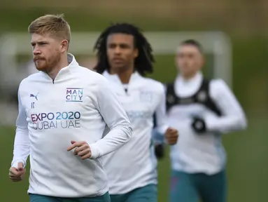 Gelandang Manchester City asal Belgia Kevin De Bruyne (kiri) melakukan pemanasan saat mengambil bagian dalam sesi latihan di tempat latihan Manchester City di Manchester, barat laut Inggris, pada 25 April 2022. Manchester City akan bertanding melawan Real Madrid pada leg pertama semifinal Liga Champions. (AFP/Oli Scarff)
 