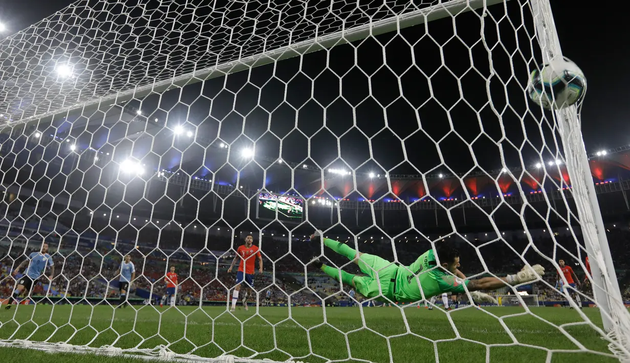 Kiper timnas Chile, Gabriel Arias gagal menghentikan sundulan striker Uruguay, Edinson Cavani pada laga terakhir grup C Copa America 2019 di stadion Maracana, Rio de Janeiro, Senin (24/6/2019). Gol tunggal Edinson Cavani dalam laga tersebut memastikan Uruguay jadi juara Grup C. (AP/Leo Correa)