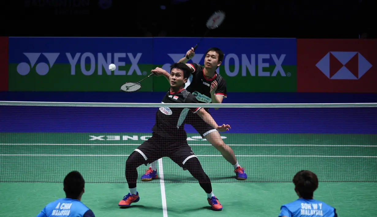 Mohammad Ahsan mencoba bermain bola pendek di laga final All England 2019 yang berlangsung di Arena Birmingham, Minggu (10/3). Di final Hendra/Ahsan menang 11-21, 21-14, 21-12 atas Aaron Chia/Soh Wooi Yik. (AFP/Oli Scarff)