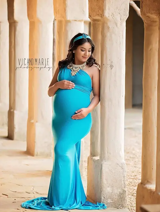 Wanita yang sedang hamil besar mengenakan gaun biru mentereng layaknya Princess Jasmine dari Aladdin. Dalam konsep pemotretan ini, Vic dan Marie menampilkan para ibu yang sedang hamil besar bak putri Disney. (Instagram/vicandmariephotography)