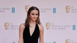 Aktris Inggris Emma Watson berpose di karpet merah saat tiba di BAFTA British Academy Film Awards di Royal Albert Hall, di London (13/3/2022). Bintang film Harry Potter ini mengenakan sepasang sepatu hak hitam runcing yang dihiasi dengan tali pergelangan kaki manik-manik. (AFP/Tolga Akmen)