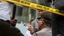 Petugas kepolisian melakukan pengecekan identitas korban bunuh diri di Menara BCA Jakarta, Selasa (7/10/2014) (Liputan6.com/Faizal Fanani)