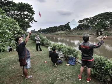 Warga bermain layang-layang di pinggir Kanal Banjir Timur (KBT), Duren Sawit, Jakarta, Senin (19/4/2021). KBT menjadi lokasi favorit warga untuk mengisi waktu menunggu buka puasa atau ngabuburit, salah satunya dengan bermain layang-layang bersama keluarga. (merdeka.com/Iqbal S Nugroho)