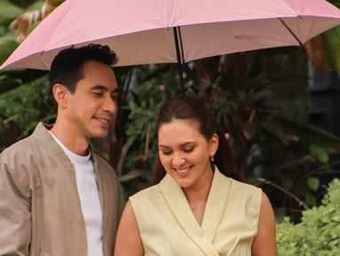 Meski belum pernah main film bareng, Darius dan Donna sudah sering dipasangkan di berbagai iklan. Kali ini, mereka menjadi bintang iklan produk keluarga dengan konsep yang hangat dan manis. Dalam suasana hujan, keduanya tampil mesra di bawah satu payung merah muda. Liputan6.com/IG/@darius_sinathrya)