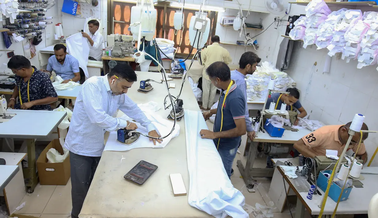 <p>Penjahit menyelesaikan produksi di tengah tingginya permintaan "dishdasha", pakaian tradisional Kuwait, di toko pakaian adat di Kuwait City pada 23 April 2022. Selama bulan suci Ramadhan dan Idul Fitri, pria dan anak laki-laki lebih suka memakai pakaian tradisional Kuwait. (YASSER AL-ZAYYAT / AFP)</p>