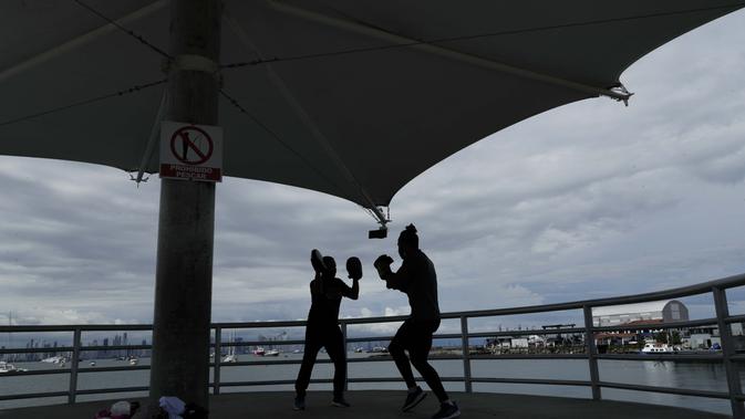 Petinju Kuba Yunier Menen (kanan) dan pelatihnya Carlos Agrazal berlatih di jalan lintas Amador di tengah pandemi COVID-19 di Panama City, Senin (14/9/2020). (AP Photo / Arnulfo Franco)