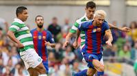 Penyerang Barcelona, Lionel Messi (kanan) saat berupaya mengamankan bola dari kawalan gelandang Celtic, Nir Bilton, pada pertandingan International Champions Cup 2016, di Dublin, Sabtu (30/7/2016). (AFP/Paul Faith). 