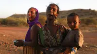 Pengungsi Ethiopia menggendong seorang anak di wilayah Qadarif, Sudan, Rabu (18/11/2020). Pertempuran yang kian meluas di perbatasan Ethiopia dan Sudan mengancam wilayah Tanduk Afrika. (AP Photo/Marwan Ali)