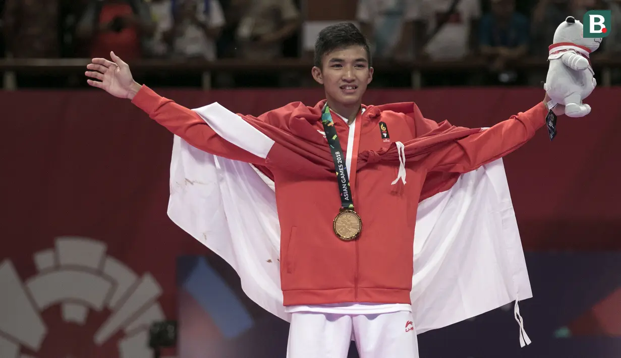 Karateka Indonesia, Rifki Ardiansyah Arrosyiid, melakukan selebrasi usai beraksi pada Asian Games di JCC Senayan, Jakarta, Minggu (26/8/2018). Rifki berhasil medapat medali emas di nomor kumite 60 kilogram. (Bola.com/Peksi Cahyo)