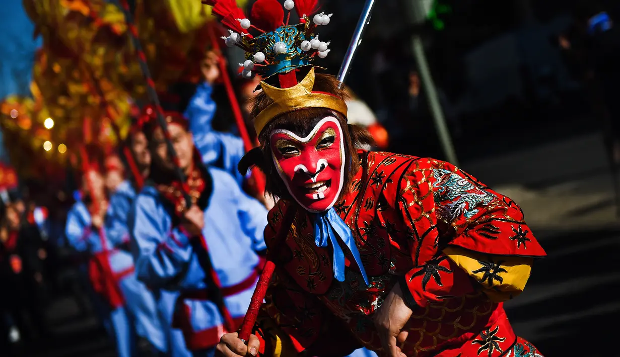 Ekspresi seorang pria yang mengenakan kostum dan topeng kera saat perayaan menjelang tahun baru China di Lisbon, Portugal (21/1).  Pada tahun baru imlek 2017 ini memasuki tahun Ayam Jantan. (AFP/Patricia De Melo Moreira)
