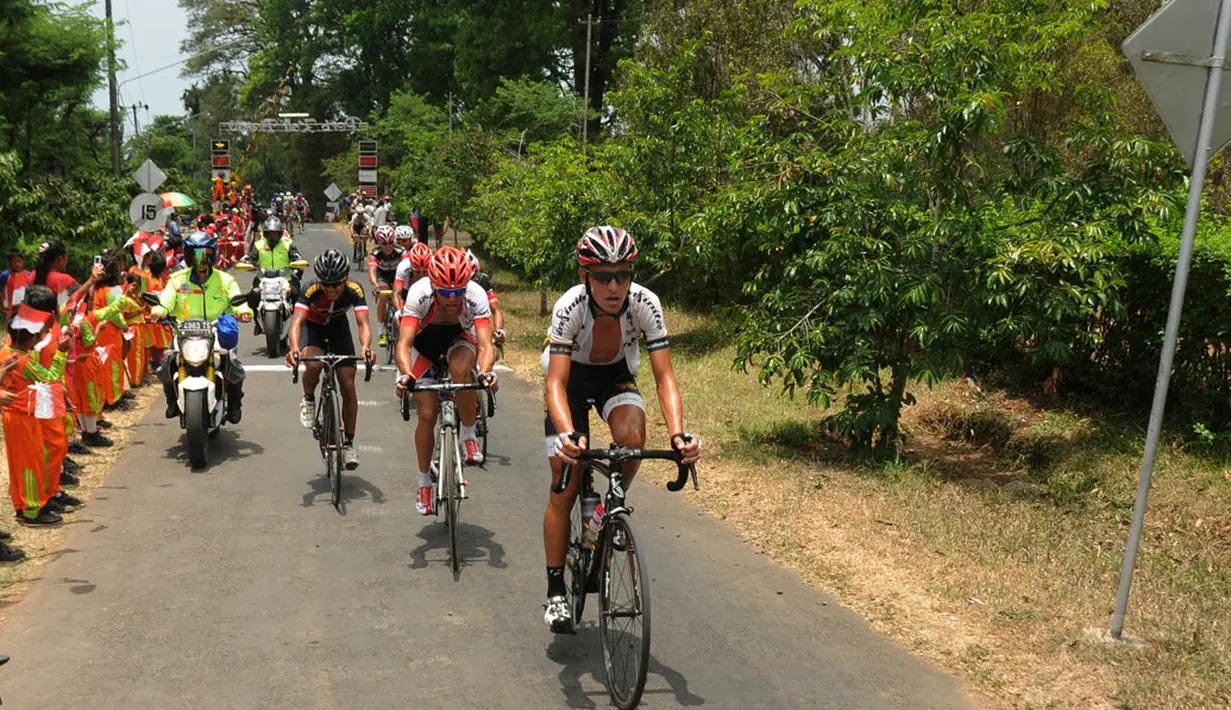 Cuaca panas dan kontur lintasan yang menanjak menjadi tantangan tersendiri di Stage I Tour De Banyuwangi Ijen. Tampak, beberapa pebalap membuka kaosnya saat berlomba, (16/10/2014). (Liputan6.com/Helmi Fithriansyah)