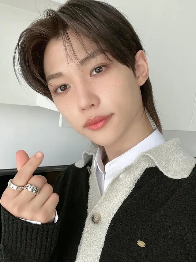 Potret Felix STRAY KIDS dengan Pose Finger Heart