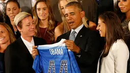 Presiden AS Barack Obama memegang jersey kehormatan saat merayakan kemenangan tim sepakbola putri Amerika pada turnamen Piala Dunia Sepakbola Putri 2015 di Gedung Putih, Washington, Selasa (27/10). (Geoff Burke-USA TODAY Sports)