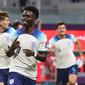 Bukayo Saka berhasil mencetak satu gol dan membantu Timnas Inggris unggul 3-0 atas Iran pada babak pertama&nbsp;laga Grup B Piala Dunia 2022 di Khalifa International Stadium, Senin (21/11/2022) malam WIB. Saka mencatatkan namanya di papan skor pada menit ke-43. (AFP/Adrian Dennis)