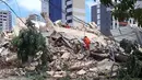 Petugas pemadam kebakaran mencari korban setelah sebuah bangunan runtuh di Fortaleza, negara bagian Ceara, Brasil, Selasa (15/10/2019). Hingga saat ini, penyebab runtuhnya rumah susun tujuh lantai tersebut masih belum diketahui. (LC Moreira/Futura Press via AP)