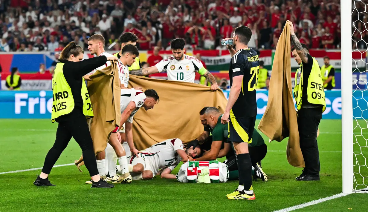 Tenda cokelat didirikan di sekitar Varga, sementara rekan setimnya dari Hungaria membentuk pagar betis di sekitar pemain tersebut. (Miguel MEDINA / AFP)