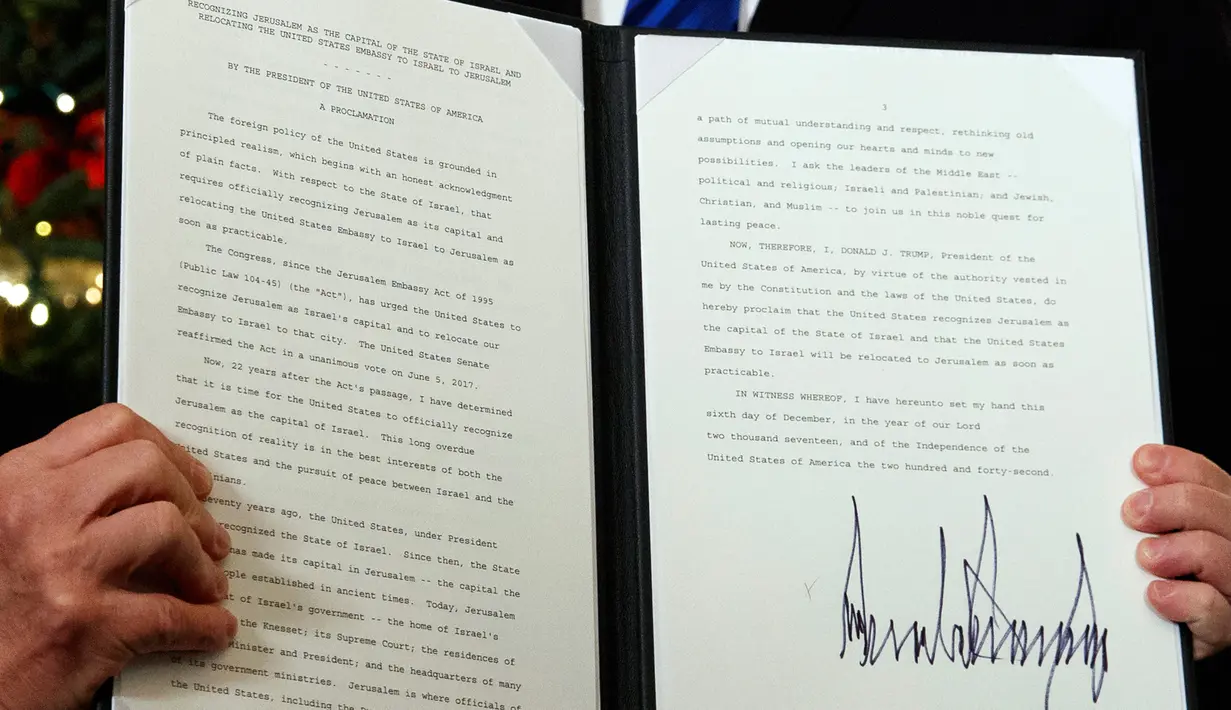Presiden AS Donald Trump menunjukkan dokumen pengumuman Yerusalem sebagai ibukota Israel yang telah ditandatangani di Ruang Penerimaan Diplomatik Gedung Putih, Washington, Rabu (6/12). (AP Photo / Evan Vucci)