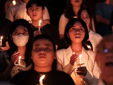 Umat Katolik memegang lilin saat Malam Paskah di gereja Santo Kristoforos di Jakarta pada 30 Maret 2024. (Yasuyoshi CHIBA/AFP)