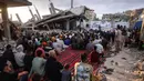 Warga Palestina berkumpul di jalan yang rusak parah untuk melaksanakan salat menandai dimulainya Idul Adha, Hari Raya Kurban, di Khan Yunis, Jalur Gaza Selatan, pada Rabu 27 Mei 2026. (BASHAR TALEB/AFP)