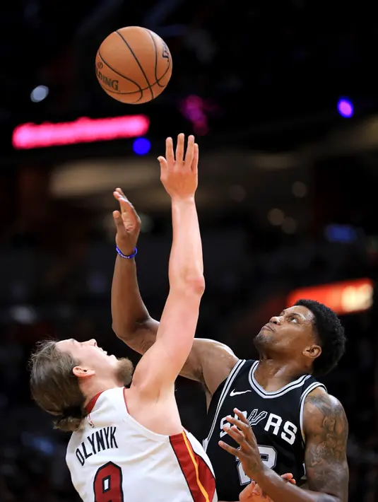 Pemain Miami Heat, Kelly Olynyk (kiri) berebut bola dengan pemain San Antonio Spurs, Rudy Gay pada laga NBA basketball game di Miami, (25/10/2017). Spurs kalahkan Heat 117-100. (Mike Ehrmann/Getty Images/AFP)