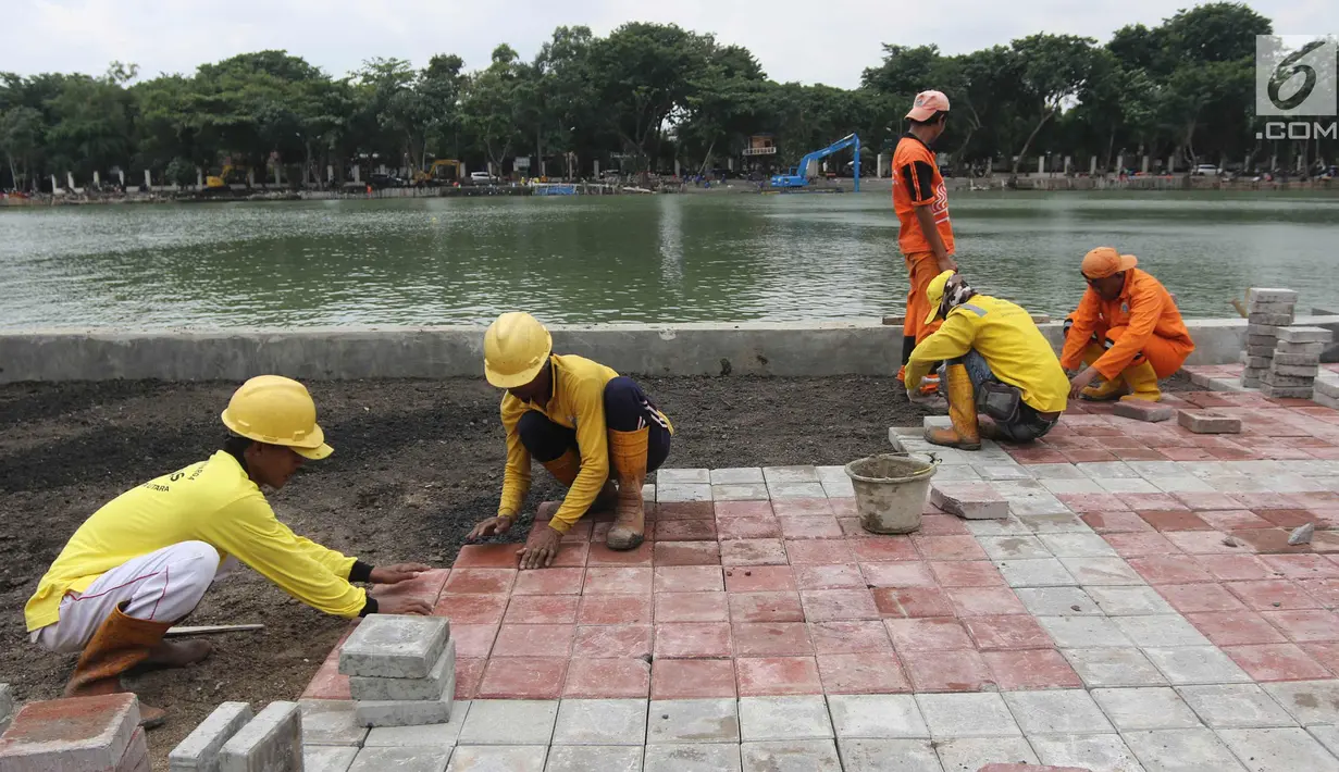 Petugas memasang konblok di pinggir Danau Sunter, Jakarta Utara, Senin (19/2). Menurut rencana, Festival Danau Sunter akan dimeriahkan sejumlah atraksi dari berbagai komunitas olahraga air seperti ski, renang, dan dayung. (Liputan6.com/Arya Manggala)