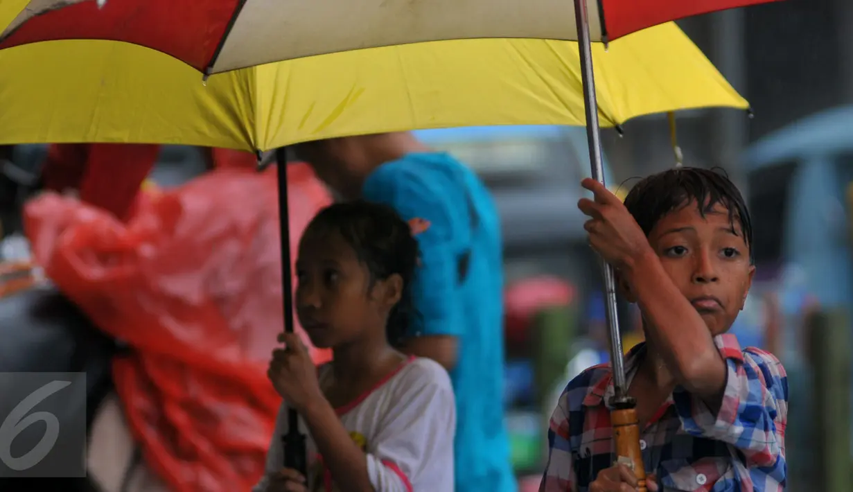 Pengojek payung saat menjajakan jasanya di kawasan Tanah Abang, Jakarta, Selasa (9/2). Tidak ada tarif khusus yang ditawarkan oleh para pengojek payung tersebut. (Liputan6.com/Faisal R Syam)