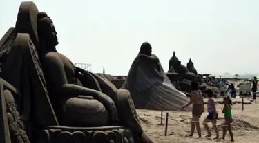 Pengunjung berjalan diantara patung pasir di pameran Asahi Sand Sculpture, Yasashigaura, pantai Asahi , Tokyo, Sabtu (11/7/2015). Pameran ini digelar mulai Senin (6/7) lalu. (AFP PHOTO/Toshifumi Kitamura)