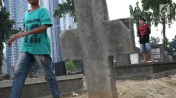 Anak-anak bermain layang-layang di TPU Menteng Pulo, Jakarta, Kamis (18/10). Padatnya pemukiman penduduk serta gedung bertingkat di kawasan tersebut menyebabkan anak-anak terpaksa bermain di tempat yang tidak semestinya. (Liputan6.com/Immanuel Antonius)