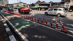 Kendaraan melintasi "stick cone" pembatas jalur sepeda di kawasan Pejompongan, Jakarta, Selasa (29/11/2022). Pemprov DKI Jakarta kembali mengganggarkan dana untuk perawatan jalur dan evaluasi pembatas sepeda pada rancangan APBD tahun anggaran 2023 sebesar Rp7,5 miliar setelah sebelumnya sempat dicoret dari anggaran dan menuai kecaman dari sejumlah pihak. (Liputan6.com/Johan Tallo)