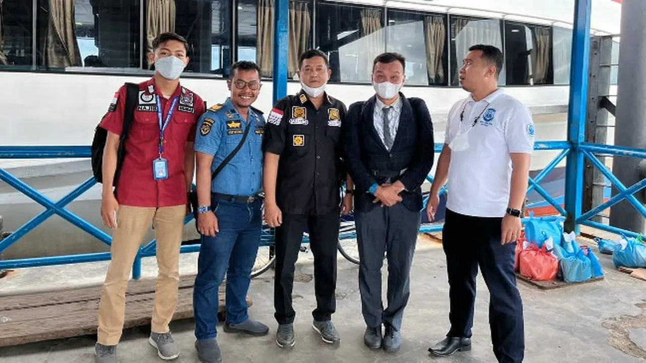 Personel Kepala Kantor Imigrasi Selatpanjang membawa WNA Singapura (berdasi) ke pelabuhan untuk dideportasi.