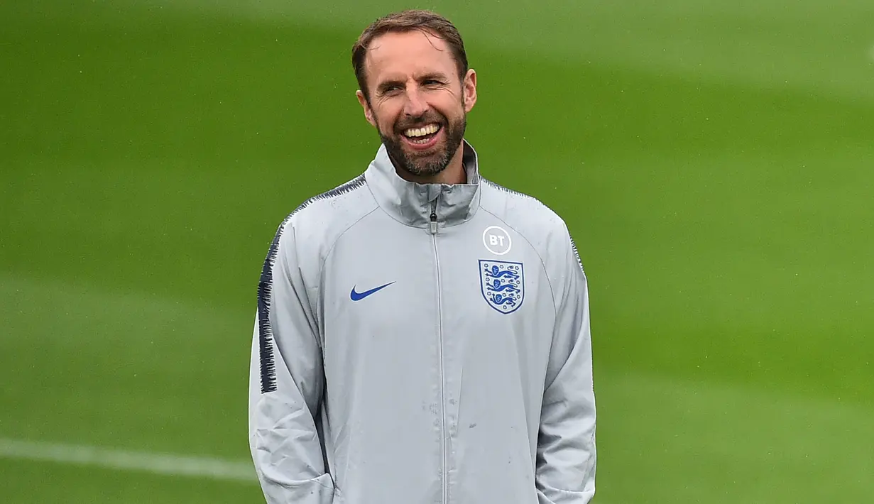 Pelatih Inggris, Gareth Southgate tersenyum saat melihat pemainnya berlatih di Staplewood Campus di southampton, Inggris selatan (9/9/2019). Inggris akan bertanding melawan Kosovo pada grup A Kualifikasi Euro 2020 di Stadion Saint Mary. (AFP Photo/Glyn Kirk)