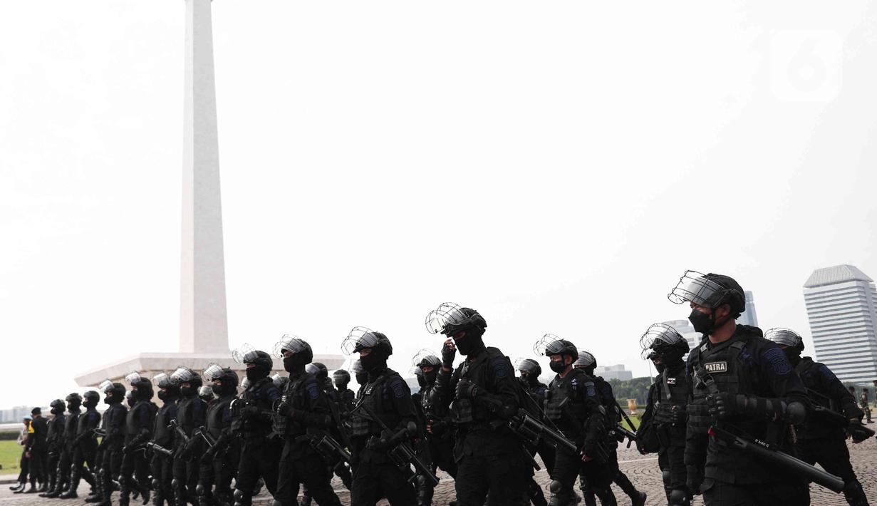 Personel Korps Brimob Polri berjalan untuk mengikuti apel gabungan gelar pasukan di Silang Monas, Jakarta, Senin (11/4/2022). Polda Metro Jaya mengerahkan sebanyak 5.620 pasukan gabungan Polri-TNI dalam rangka pengamanan aksi unjuk rasa BEM SI. (Liputan6.com/Herman Zakharia)