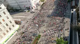 Ribuan atlet melintasi jembatan yang berada di atas sungai Danube sesaat setelah dimulainya Vienna City Marathon 2018 di Wina, Austria, Minggu (22/4). Acara lari maraton ini diikuti  peserta dari berbagai negara. (AP Photo /Ronald Zak)