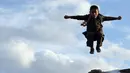 Seorang anak melompat di atas bangkai tank Soviet di puncak bukit di pinggiran Kabul, Afghanistan (4/3). Bangkai tank bekas perang ini jadi tempat bermain anak-anak Afghanistan. (AP Photo/Rahmat Gul)