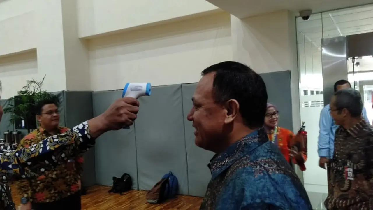 Ketua KPK Firli Bahuri dicek suhu tubuhnya saat akan masuk ke kantor.